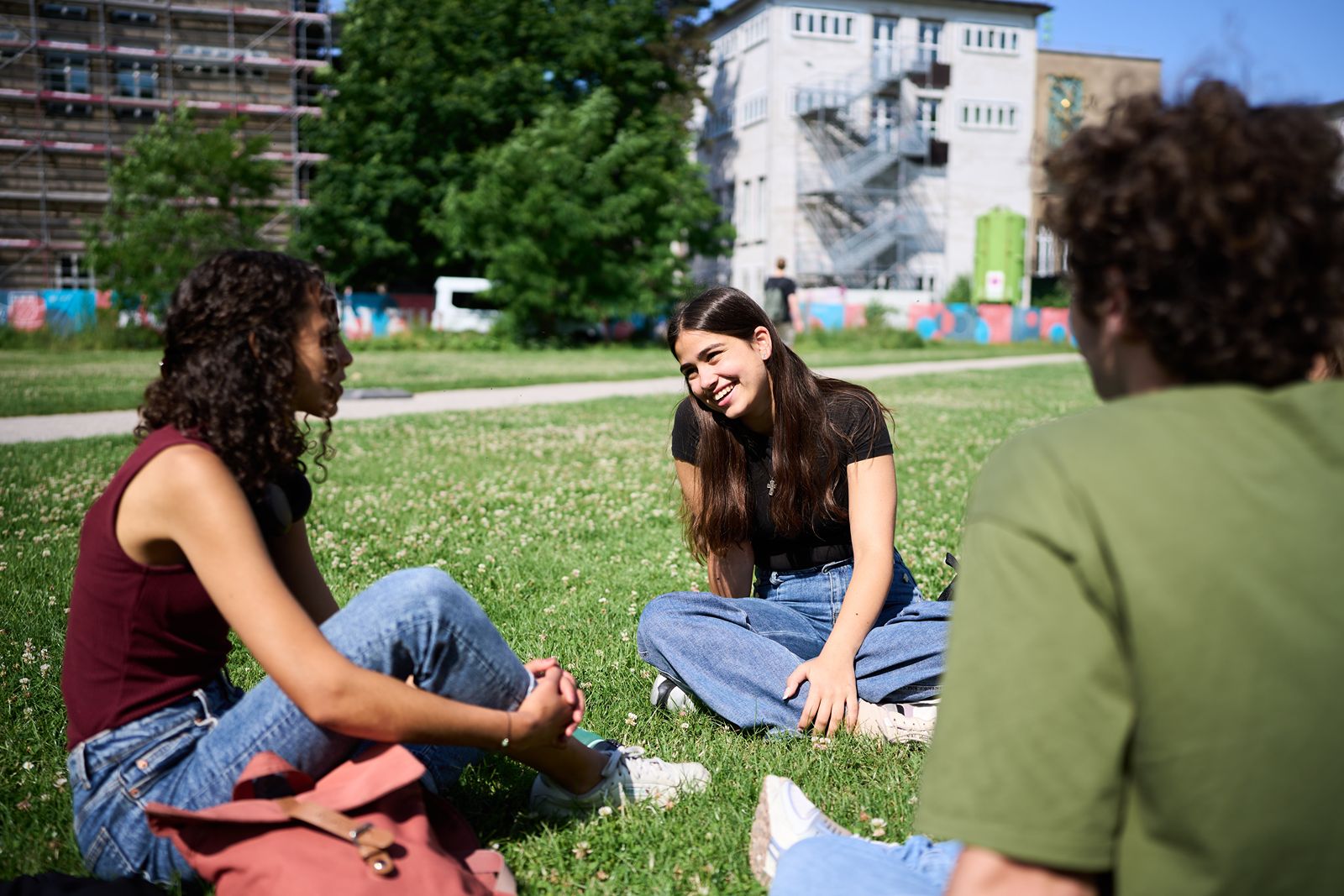 Students are sitting on a lawn directly in front of the Mensa Z&uuml;lpicher Stra&szlig;e in Cologne, which is marketed by Deutsche Hochschulwerbung