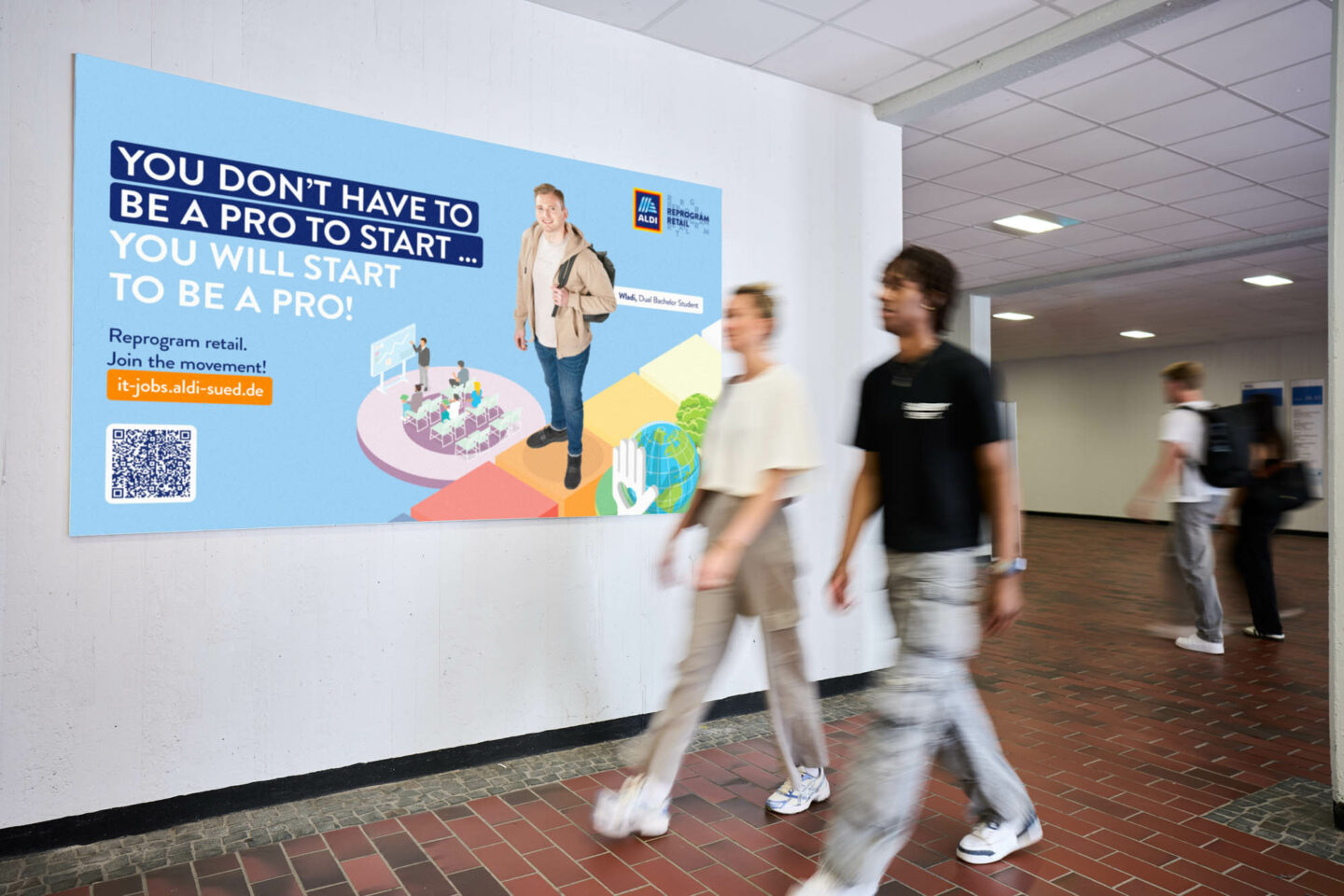 A premium wall mounted on the wall, with two students walking past it on their way to the lecture
